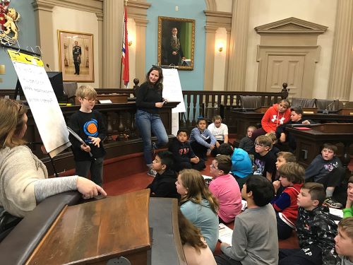 Student shares journal in front of classmates.
